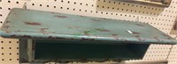 Teal green shelf unit, with three hooks on the