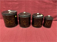 4 piece toll canister set with floral stenciling.