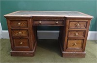 Oak seven drawer pedestal desk with gilt tooled