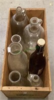 Wooden crate of vintage bottles contains glass