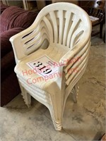 Seven white plastic chairs