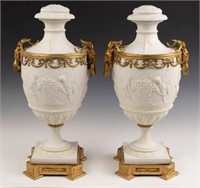 Pair of Bisque Porcelain Urns w/ Gilded Ram Heads.