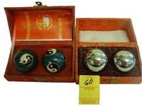 Two sets of cased meditation balls