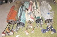 5 golf bags with clubs