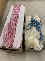 Three boxes of plastic imitation pearls. Two pink