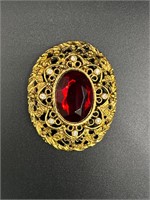 Red and gold toned brooch