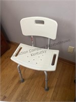 A shower chair and an adjustable bedside table