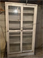 A metal cabinet with 6 shelves and sliding glass