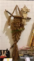 Two macramé owls with wooden sticks for the perch