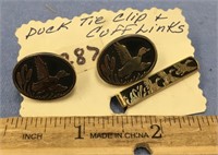 A pair of cufflinks and a matching tie clip, with