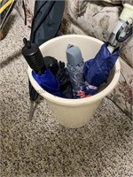 Small plastic trashcan filled with umbrellas