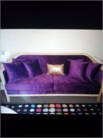 Purple couch with wood frame and throw pillows