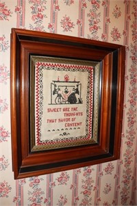 Shadow box frame containing an old sampler -
