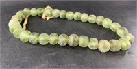 Large sand cast green glass beads about 24" open