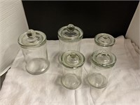 Five glass canisters with lids