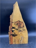 Wood burl painting of a bear with fish in mouth
