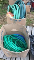 2 boxes of garden hoses and water buckets