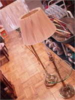 Two brass floor lamps with shades: one has