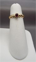 14K Yellow gold ring with reddish/purple stone.