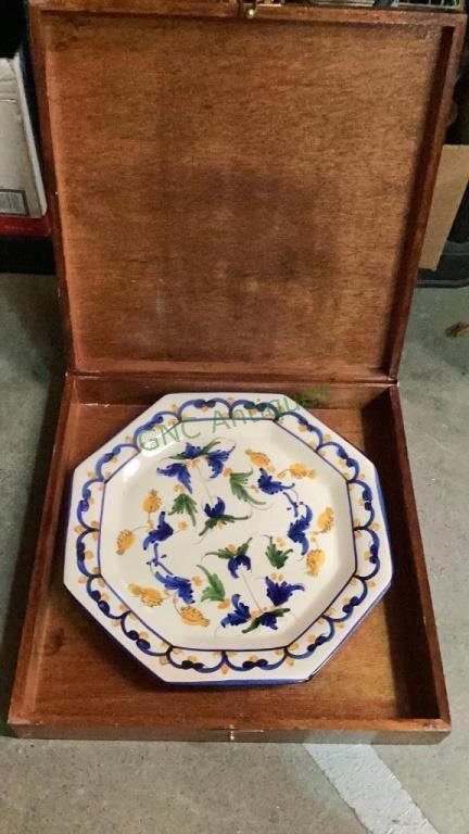 Wooden box with a large decorative plate inside.