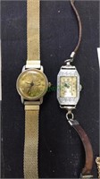 Two ladies watches, one with a gold tone coin