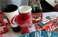 Coca Cola banner, bottles - some full, glasses,