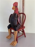 Wood  rooster on antique small red chair