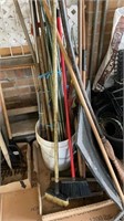 Variety of brooms & wooden stakes