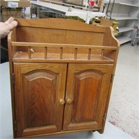 Wood cabinet w/ towel bar.