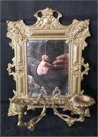 Brass-framed wall mirror and candle holder