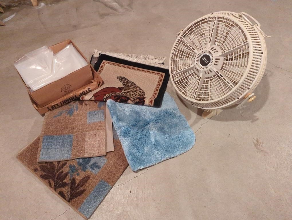 Collection of rugs, plastic sheeting and a fan