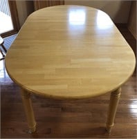Light wood oval table with one leaf.