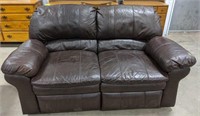 Double reclining brown faux leather loveseat.