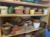 Two shelves of planters and pottery