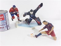 2 figurines de joueurs de hockey et 1 de soccer