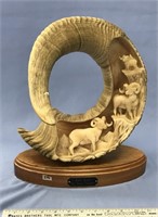 Ram horn with relief carvings of rams on mountains