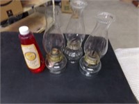 3 oil lamps and bottle of oil