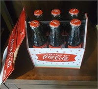 Coke bottles and carrier on shelf