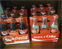 Coke bottles on shelf some full
