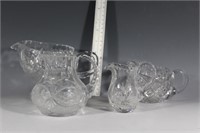 Four small crystal pitchers