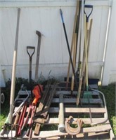 Pallet full of yard tools includes rakes, pitch