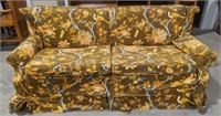 Sleeper couch with floral and bird cover. Cover