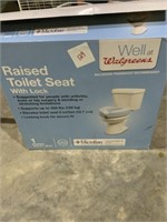 Raised toilet seat with lock