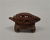 HAND CARVED NUT ON STAND IN THE FORM OF A BOAT