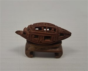 HAND CARVED NUT ON STAND IN THE FORM OF A BOAT