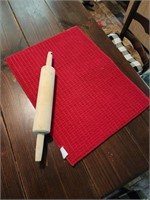 Wooden rolling pin and red dish mat