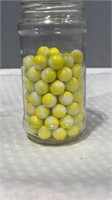 90 yellow white marbles in jar.
