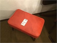 Vintage orange footstool on wooden legs
