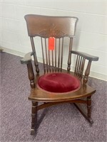 Antique rocker with curved back and padded seat