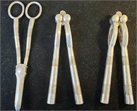 two nut crackers and a set of tongs